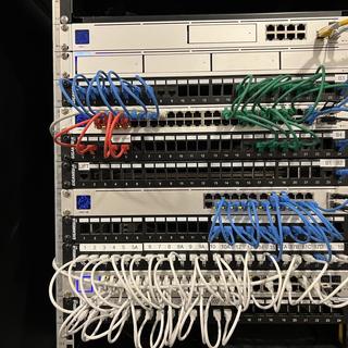 Patchkast met UniFi-switches en kleurgecodeerde bekabeling per functie