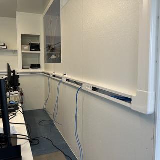 Nieuwe netwerkbekabeling en wandgoot met stroom en data per werkplek