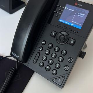 VoIP-toestel van Poly met draadloze headset op kantoor