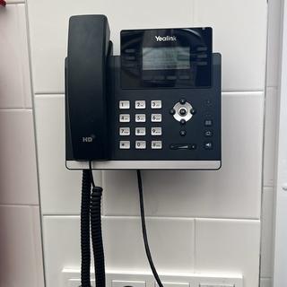 Yealink-toestel aan de wand, netjes bekabeld