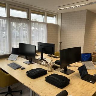 Kantoorwerkplekken ingericht met Lenovo-schermen en ThinkPads