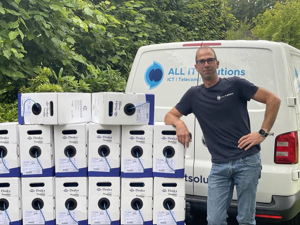 Yoeri van Meurs next to the ALL IT Solutions company van, beside boxes of network cable